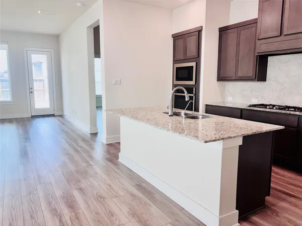 a kitchen with granite countertop a sink and dishwasher with wooden floor