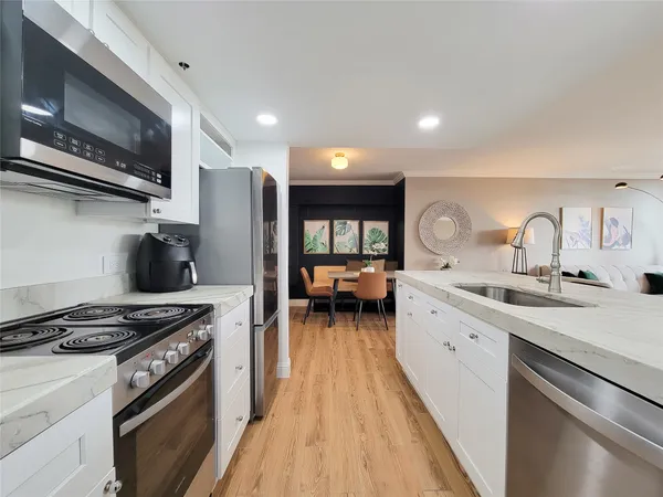 a kitchen with a sink and living room view