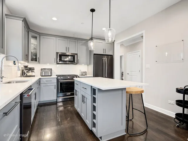 a kitchen with a sink a counter top space stainless steel appliances and cabinets