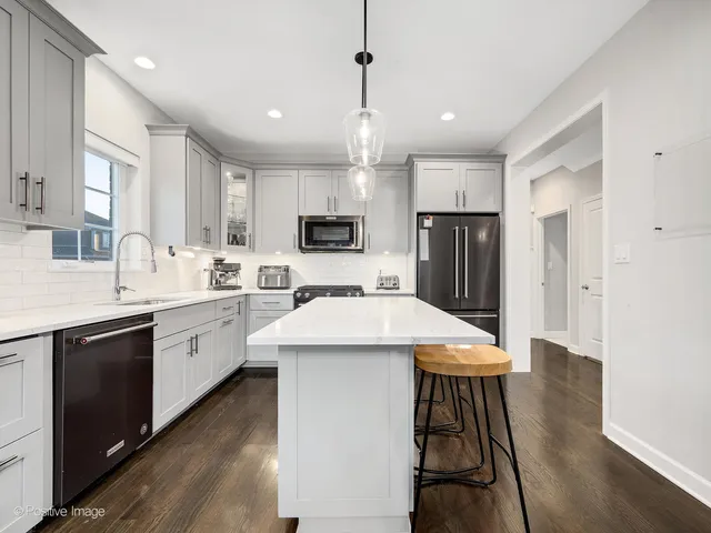 a kitchen with kitchen island a sink appliances and cabinets