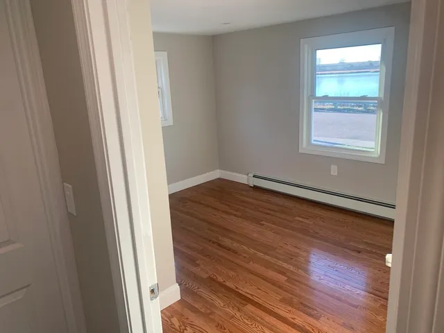 a view of empty room with wooden floor