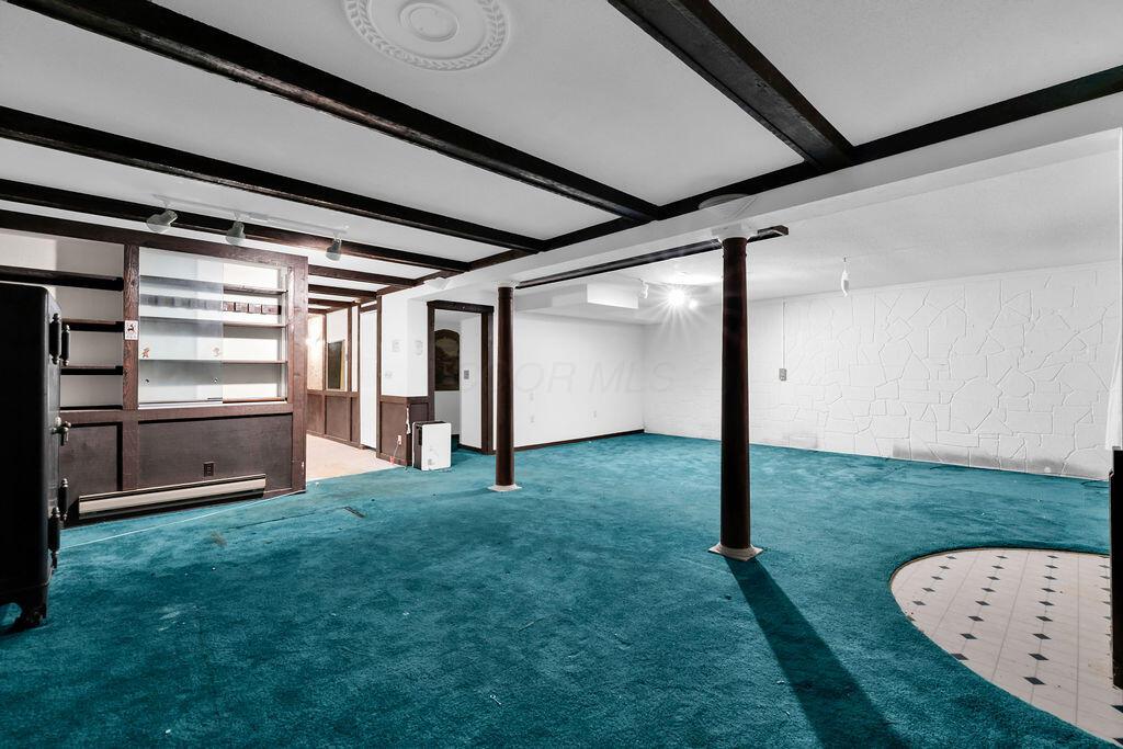 4409 Newton Road Northeast Newark, OH 43055 - Photo 58 of 87 • Green carpet • Ivory painted walls • Decorative ceiling beams • Track lighting • Walks-out to side yard • Built-in bookshelves with cabinets • Open to Billiard’s Area