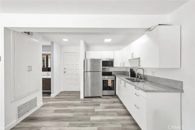 a kitchen with granite countertop a sink stainless steel appliances and cabinets