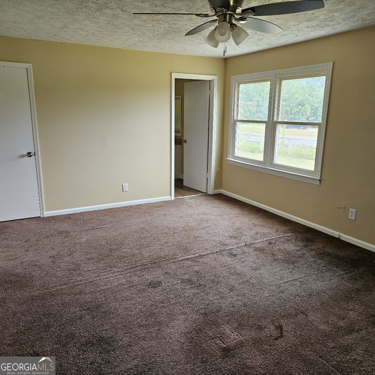 7067 Moseley Road Fort Valley, GA 31030 - Photo 15 of 37 an empty room with a ceiling fan and window