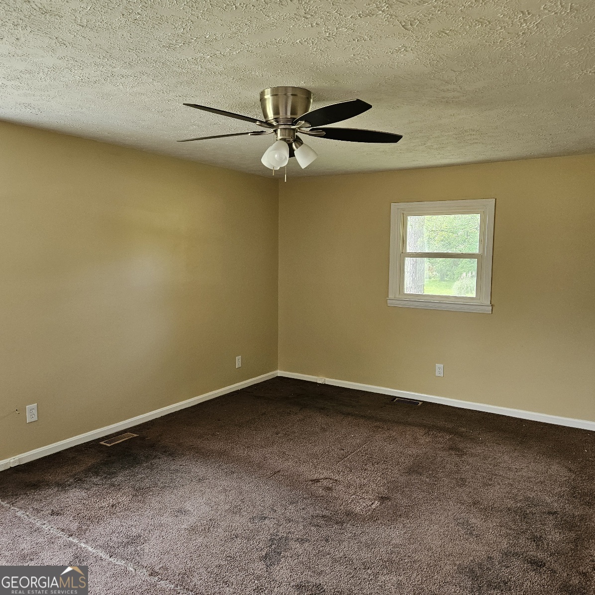 7067 Moseley Road Fort Valley, GA 31030 - Photo 17 of 37 an empty room with a window and a ceiling fan