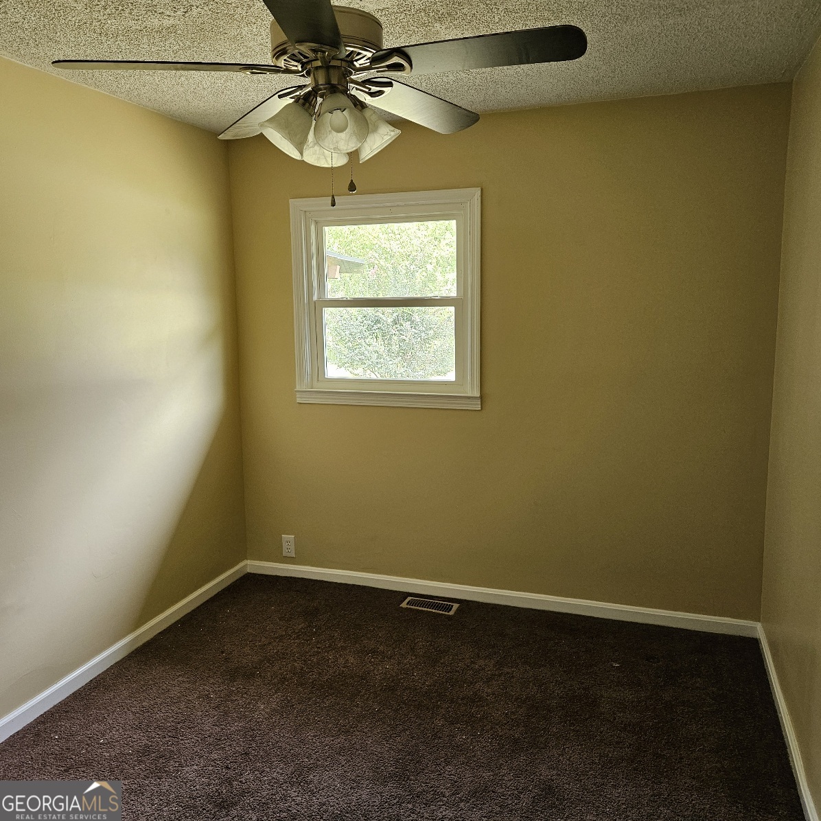 7067 Moseley Road Fort Valley, GA 31030 - Photo 21 of 37 an empty room with a window and a fan