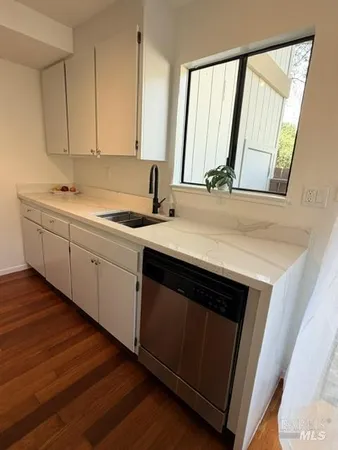 a kitchen with a sink cabinets and wooden floor
