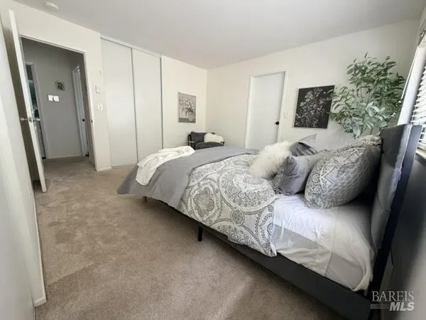a bedroom with a bed and a painting on the wall