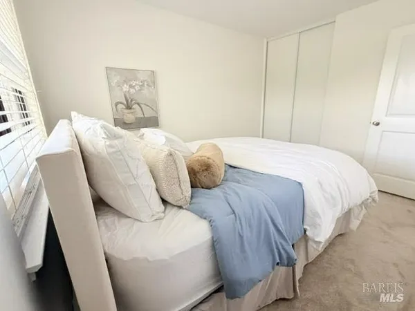 a bedroom with a bed chair and window
