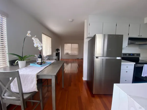 a kitchen with stainless steel appliances a refrigerator a stove a dining table and chairs