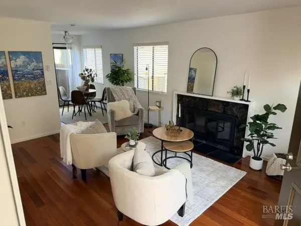 a living room with furniture a fireplace a potted plant and a fireplace