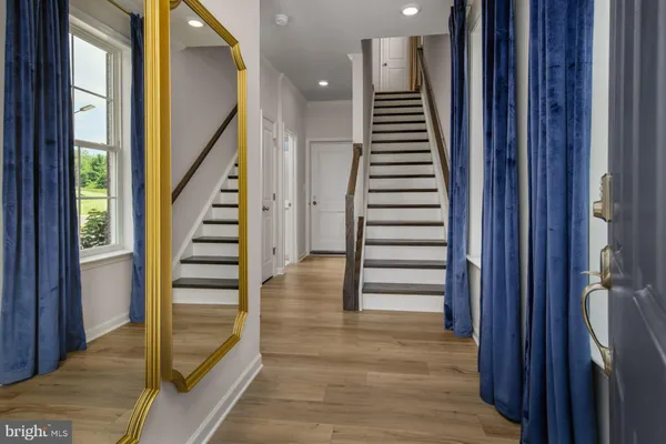 a view of a hallway with wooden floor and stairs