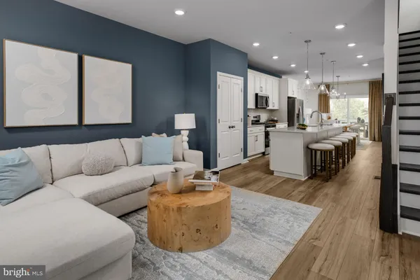 a living room with furniture kitchen view and a large window