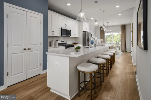 a kitchen with stainless steel appliances kitchen island granite countertop a stove a sink a refrigerator and chairs