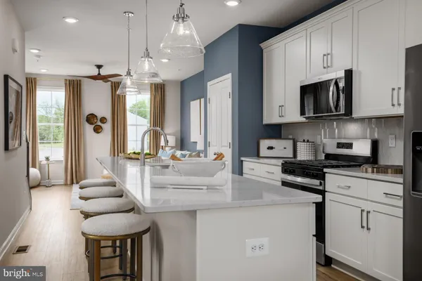 a kitchen with stainless steel appliances kitchen island granite countertop a lot of cabinets and refrigerator
