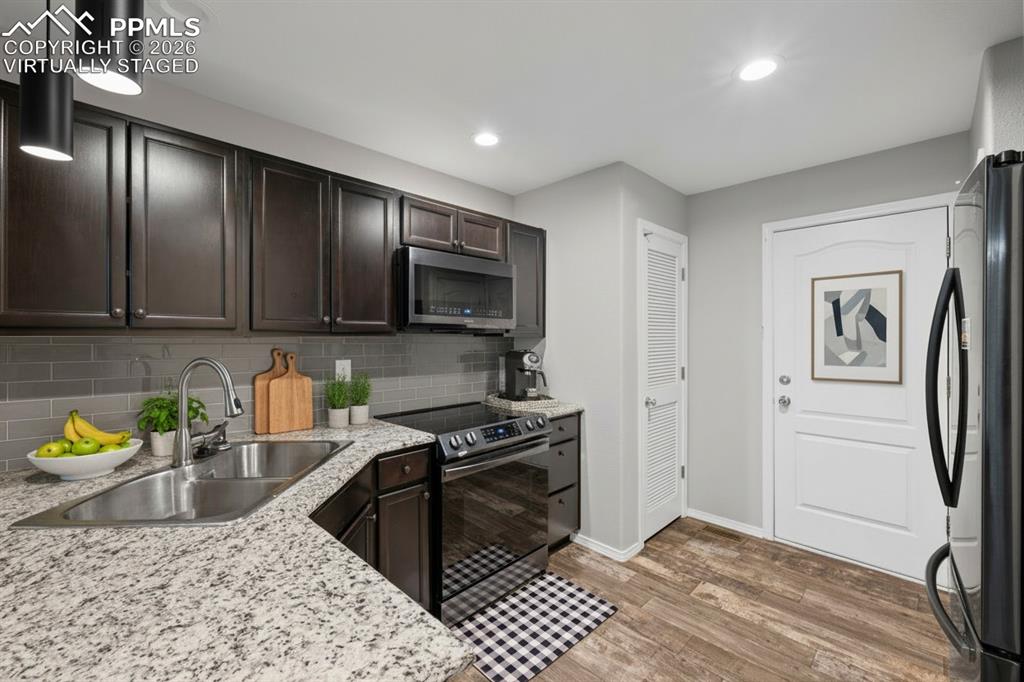 3214 Apogee View Colorado Springs, CO 80906 - Photo 11 of 33 a kitchen with stainless steel appliances granite countertop a stove a sink and a microwave