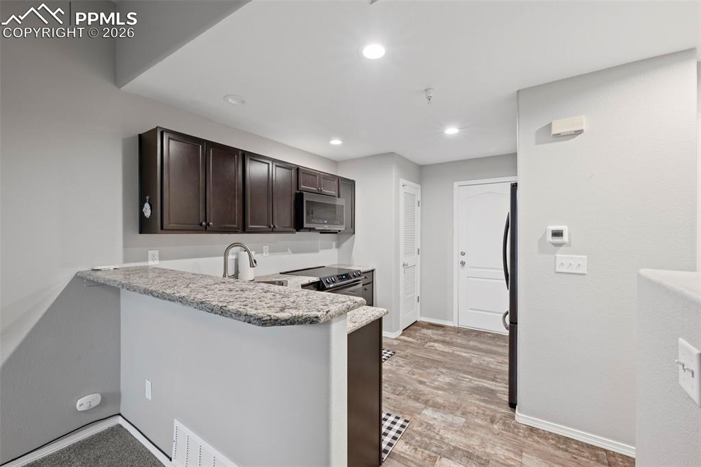 3214 Apogee View Colorado Springs, CO 80906 - Photo 23 of 33 a kitchen with stainless steel appliances granite countertop a sink and a stove top oven