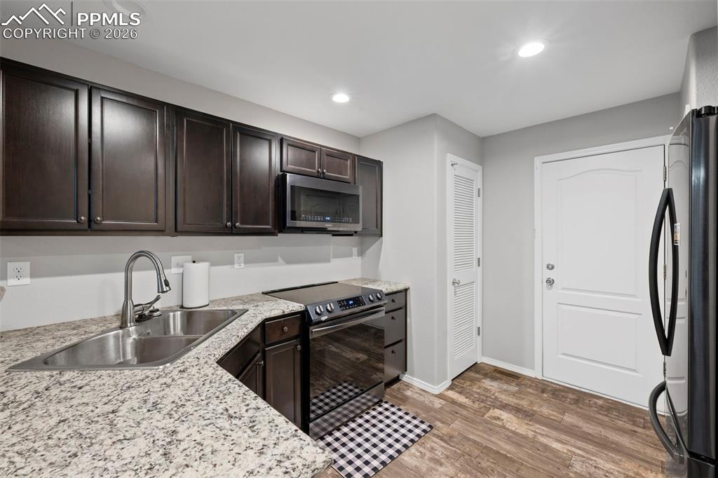 3214 Apogee View Colorado Springs, CO 80906 - Photo 24 of 33 a kitchen with stainless steel appliances granite countertop a sink a stove and a refrigerator
