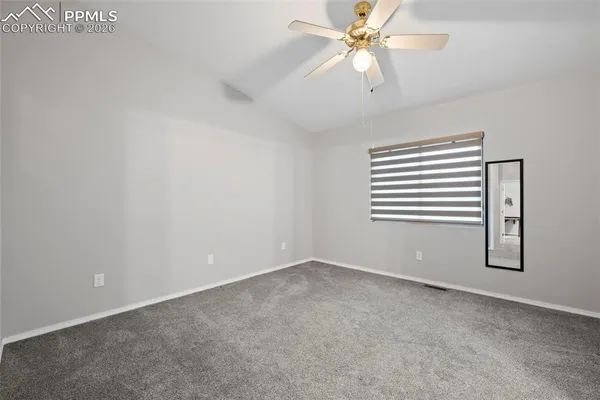 an empty room with windows and fan