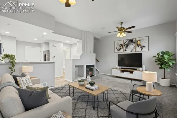 a living room with furniture a flat screen tv and a fireplace