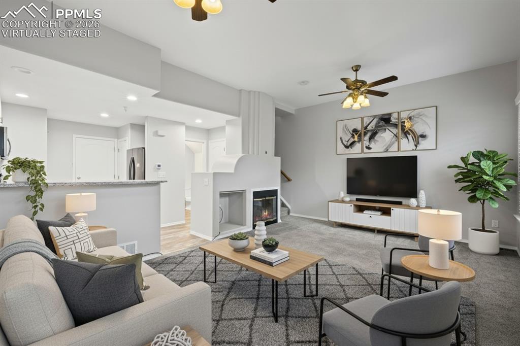 3214 Apogee View Colorado Springs, CO 80906 - Photo 10 of 33 a living room with furniture a flat screen tv and a fireplace