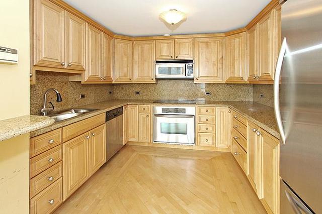 21 West Goethe Street, Unit 19C Chicago, IL 60610 - Photo 5 of 14 a large kitchen with stainless steel appliances granite countertop a stove a sink dishwasher and a refrigerator