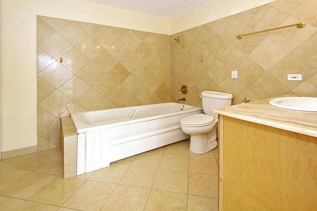 21 West Goethe Street, Unit 19C Chicago, IL 60610 - Photo 6 of 14 a bathroom with a sink a toilet and a shower