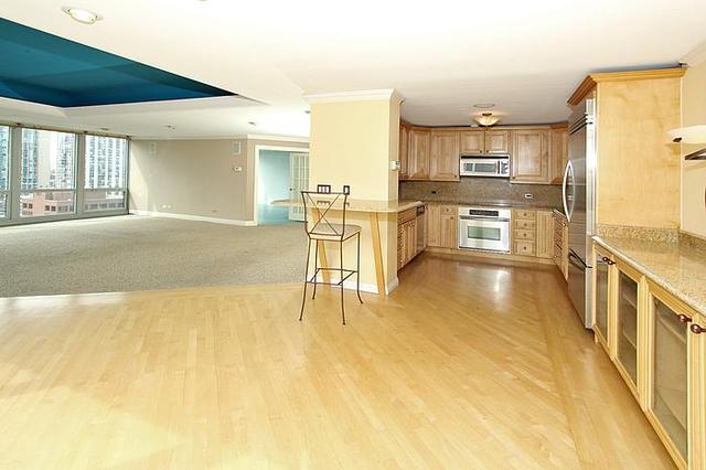 21 West Goethe Street, Unit 19C Chicago, IL 60610 - Photo 10 of 14 a view of a kitchen with kitchen island granite countertop lots of counter top space and furniture