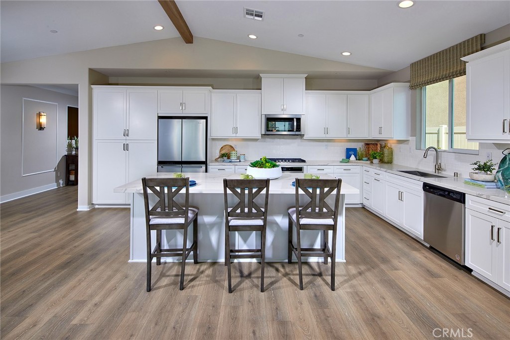 30934 Campania Road Highland, CA 92346 - Photo 6 of 19 a kitchen with stainless steel appliances a dining table chairs stove microwave and cabinets
