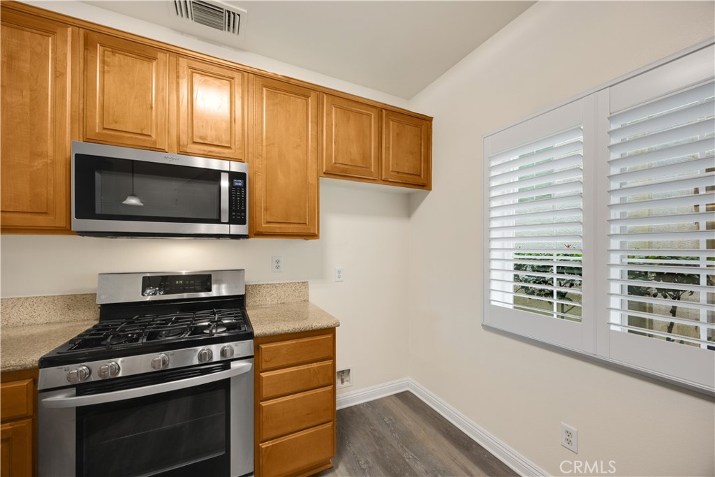 93 Kansas Street, Unit 705 Redlands, CA 92373 - Photo 14 of 33 a kitchen with stainless steel appliances a stove a microwave and cabinets