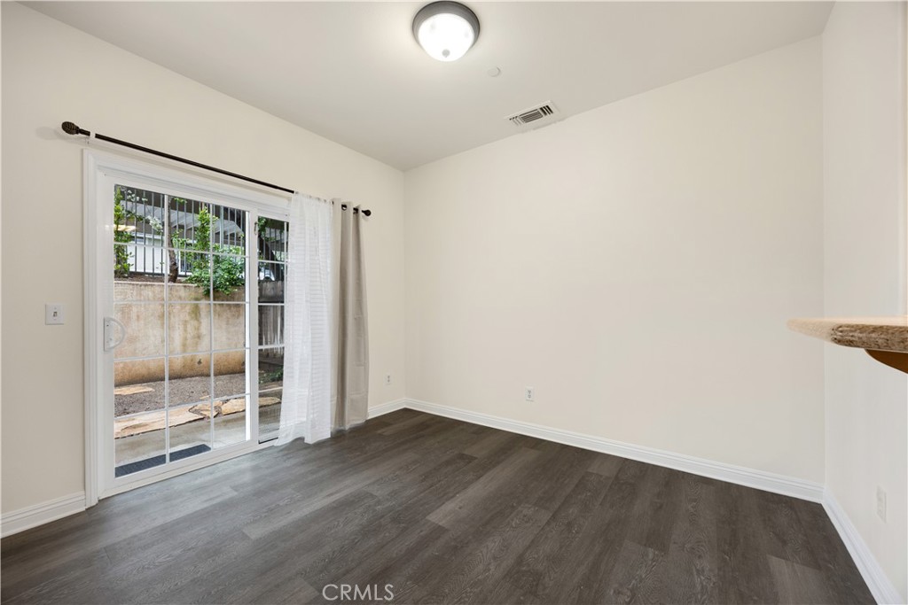 93 Kansas Street, Unit 705 Redlands, CA 92373 - Photo 8 of 33 an empty room with wooden floor and windows