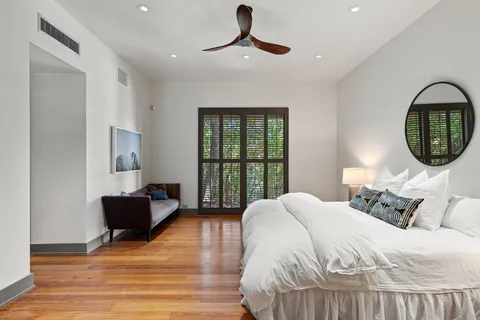 a bedroom with a bed mirror and window