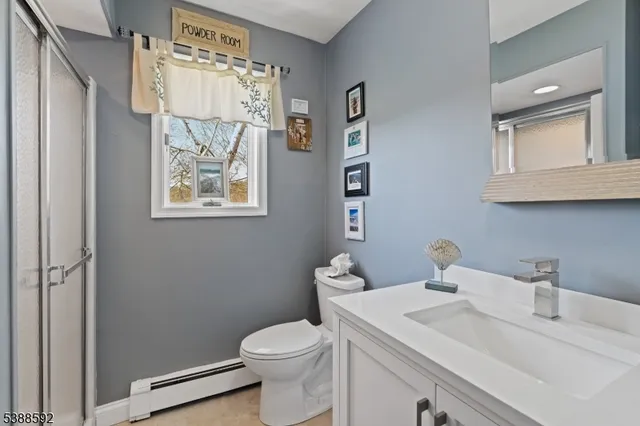 a bathroom with a sink vanity mirror and toilet