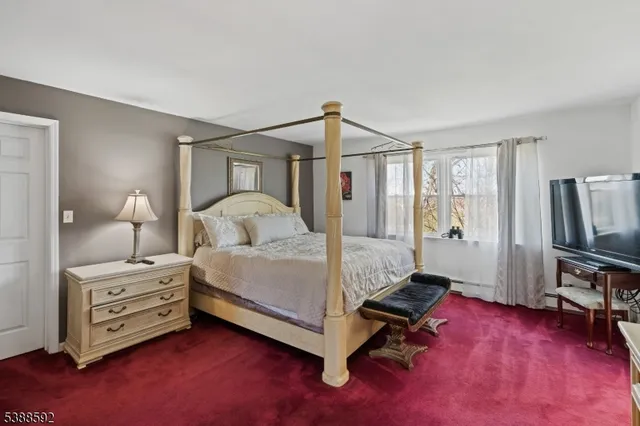 a bedroom with a bed and a tv on the dresser