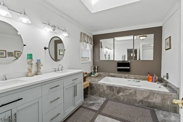 a en suite bathroom with double vanity and a mirror