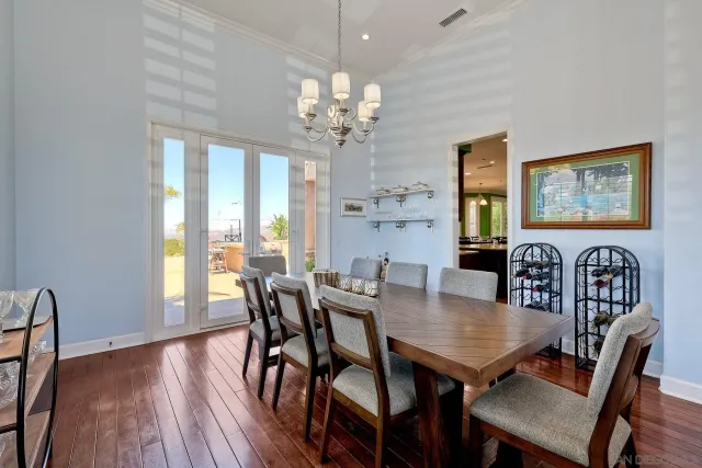 a kitchen with stainless steel appliances granite countertop wooden floor a dining table and chairs