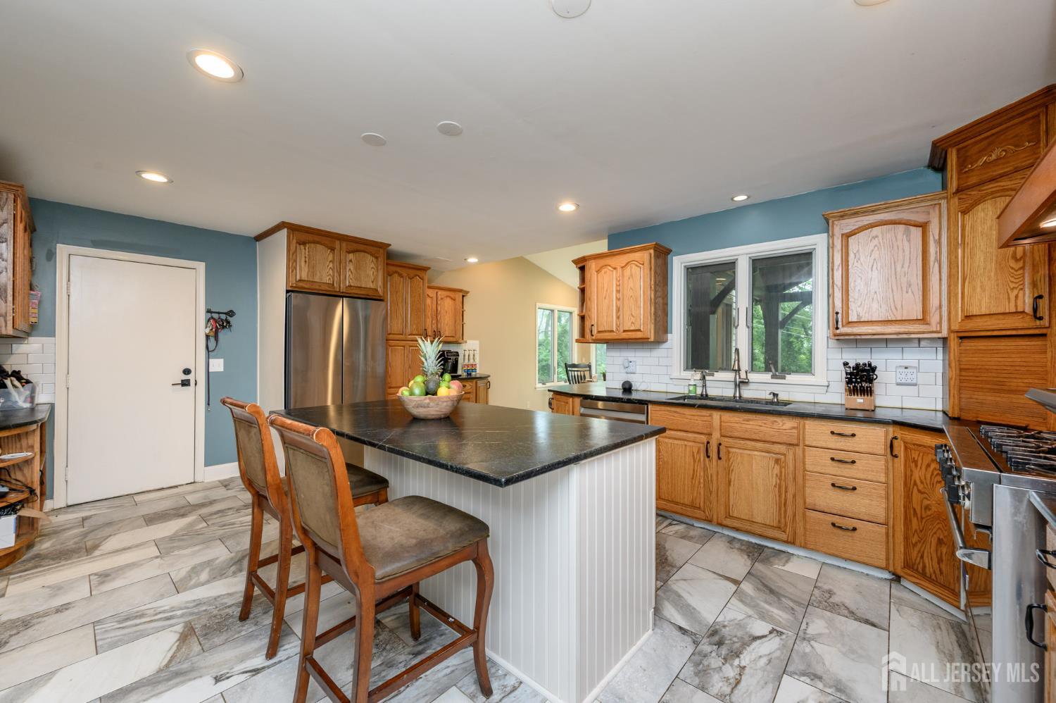 16 Pinewood Lane Washington, NJ 07882 - Photo 18 of 45 a kitchen with stainless steel appliances granite countertop a sink a stove a refrigerator dining table and chairs
