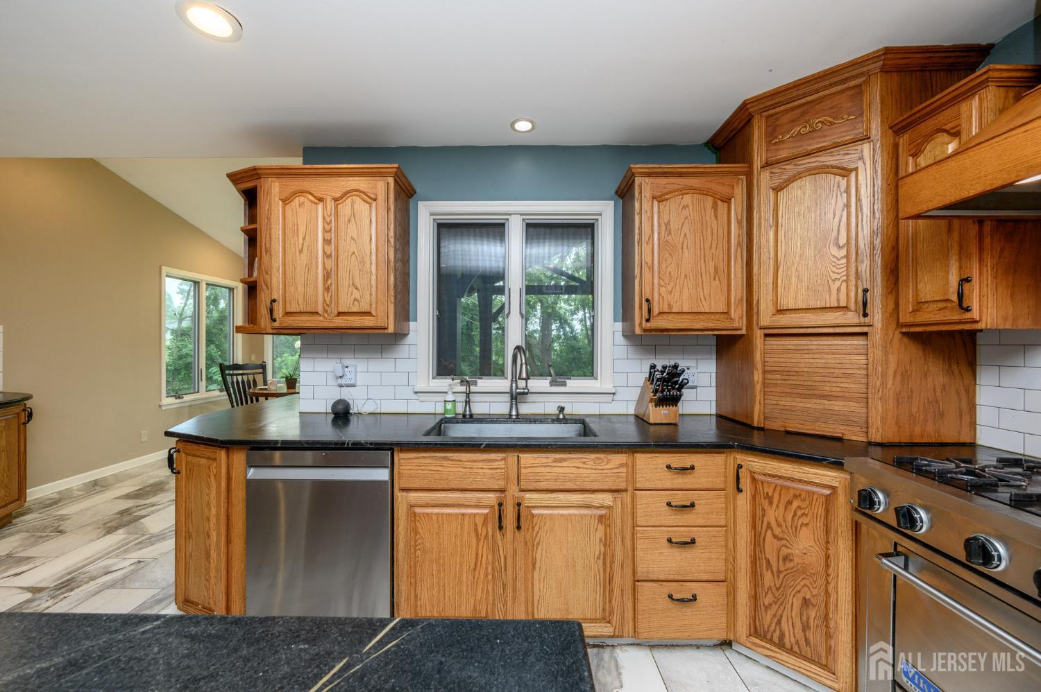 16 Pinewood Lane Washington, NJ 07882 - Photo 20 of 45 a kitchen with stainless steel appliances granite countertop a sink stove and cabinets