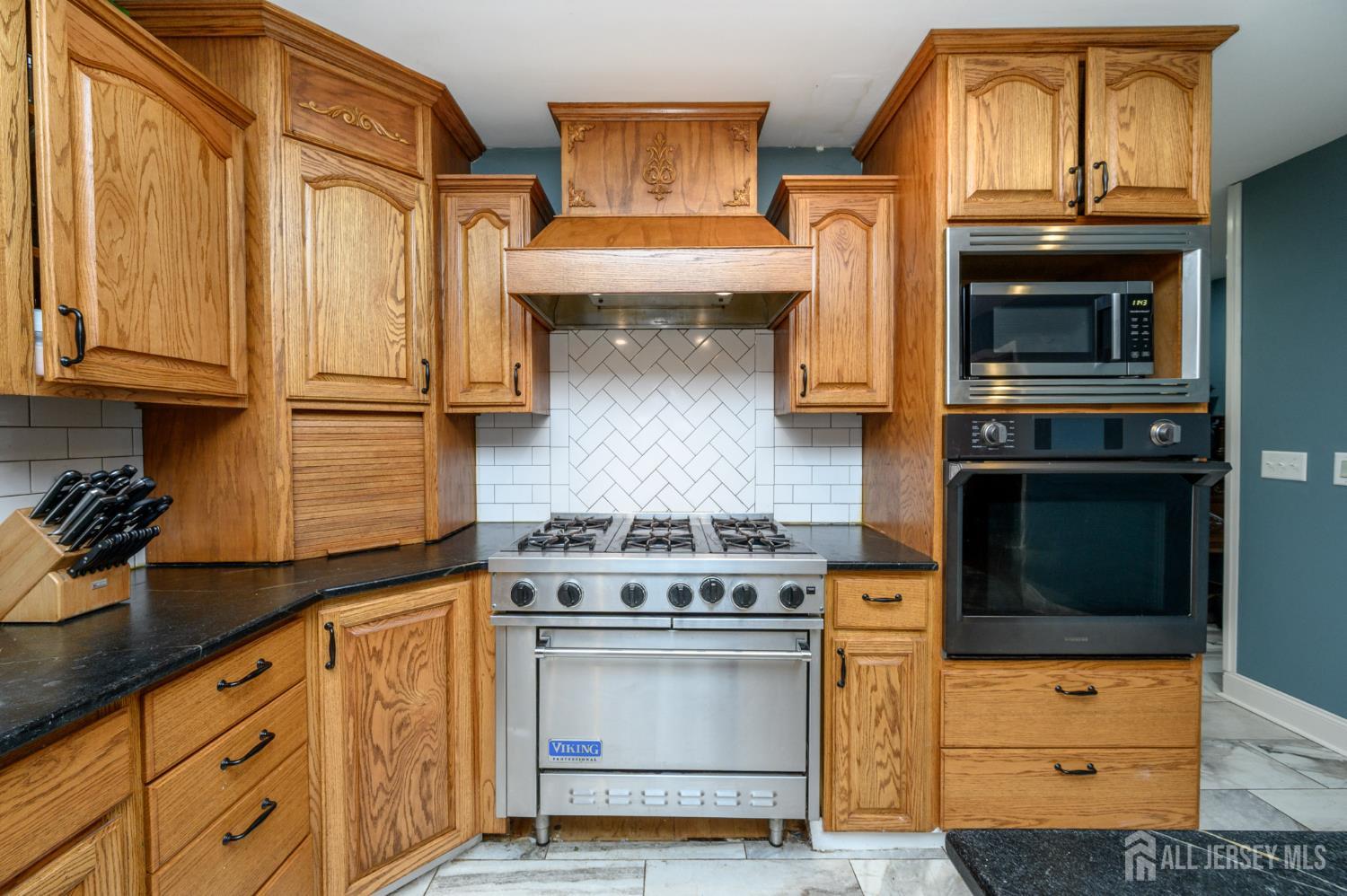 16 Pinewood Lane Washington, NJ 07882 - Photo 21 of 45 a kitchen with granite countertop cabinets stainless steel appliances and wooden floor