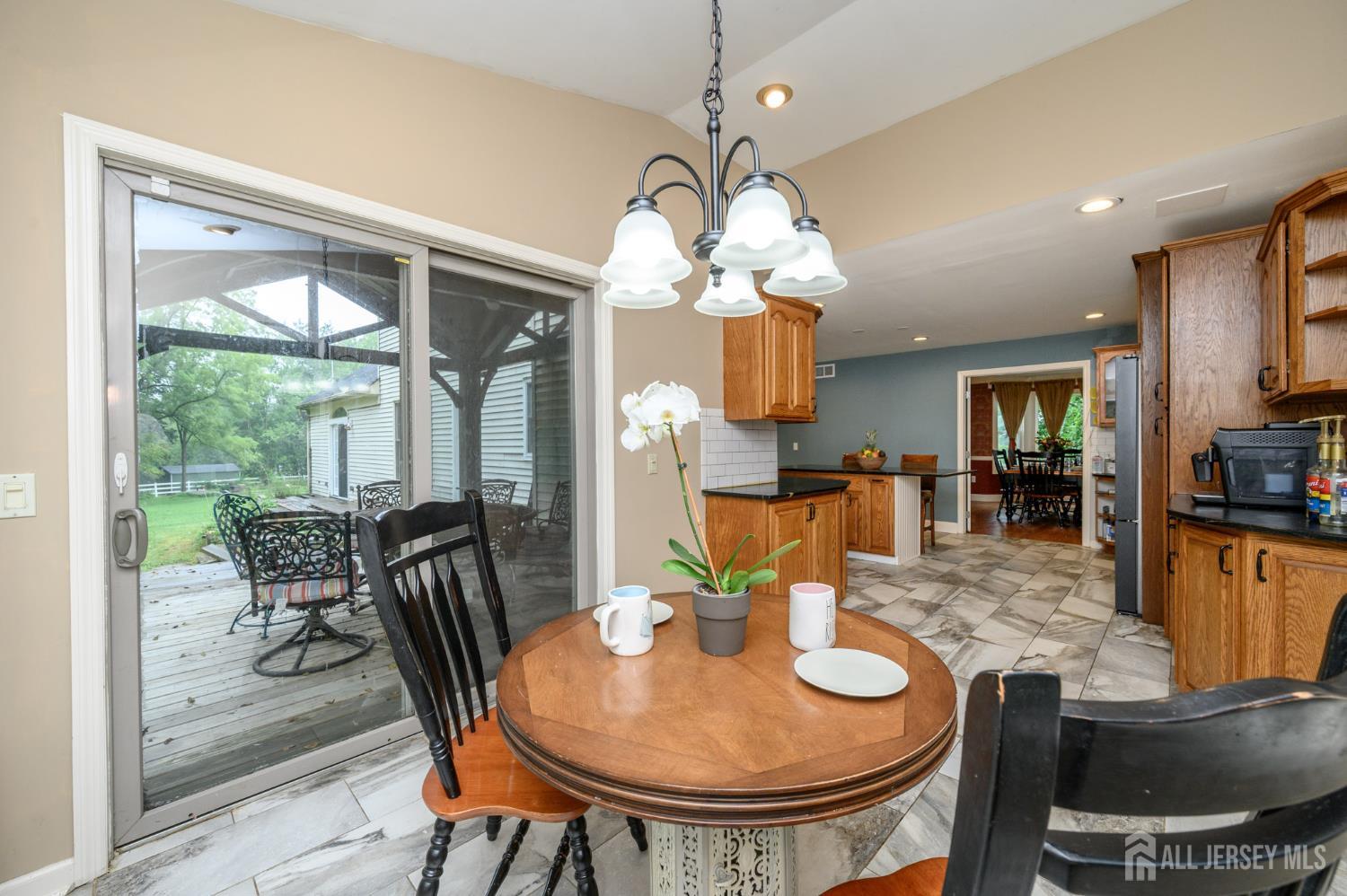 16 Pinewood Lane Washington, NJ 07882 - Photo 25 of 45 a view of a dining room with furniture a chandelier and large windows