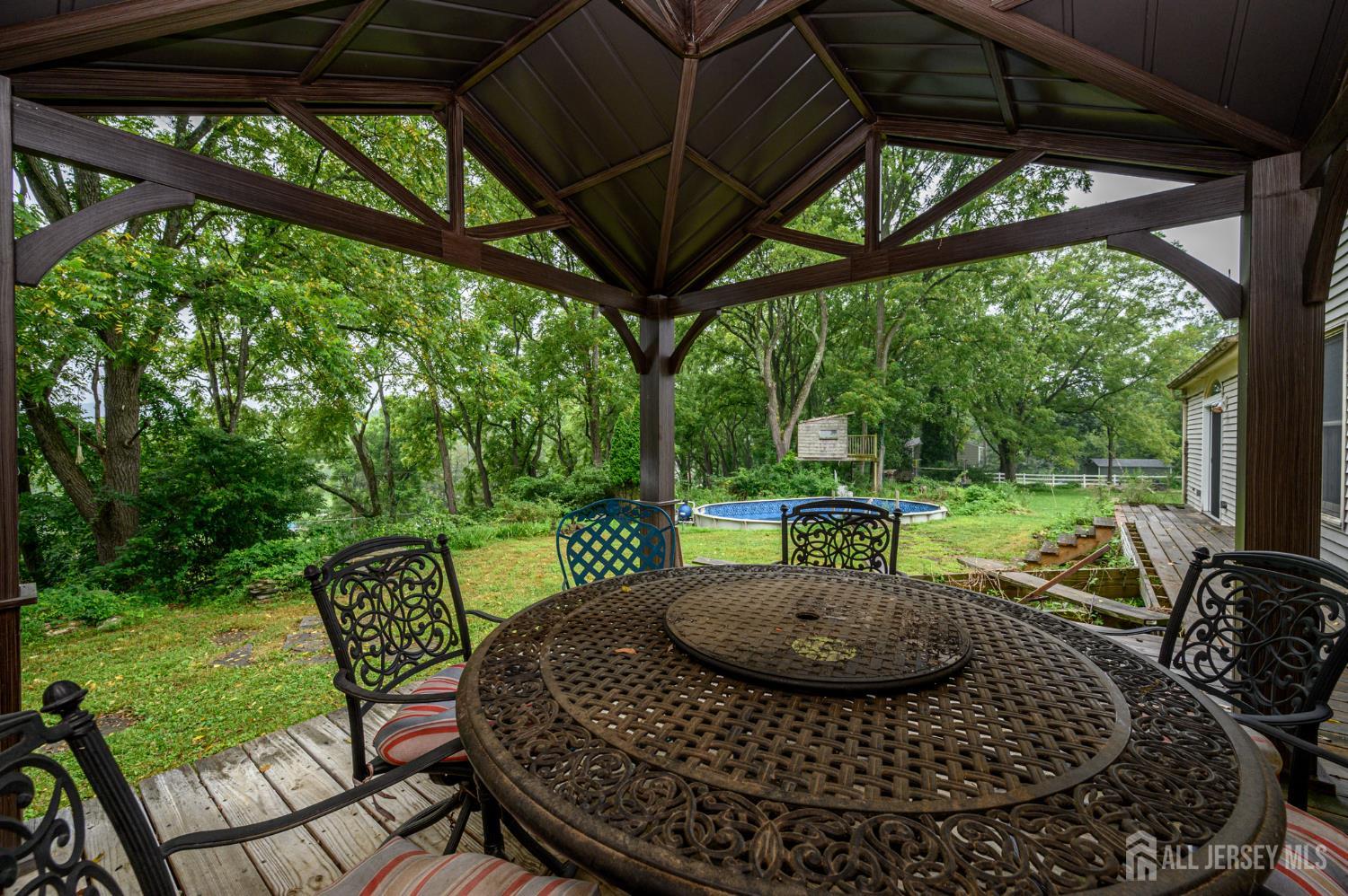 16 Pinewood Lane Washington, NJ 07882 - Photo 37 of 45 a view of a patio with a table chairs and a backyard