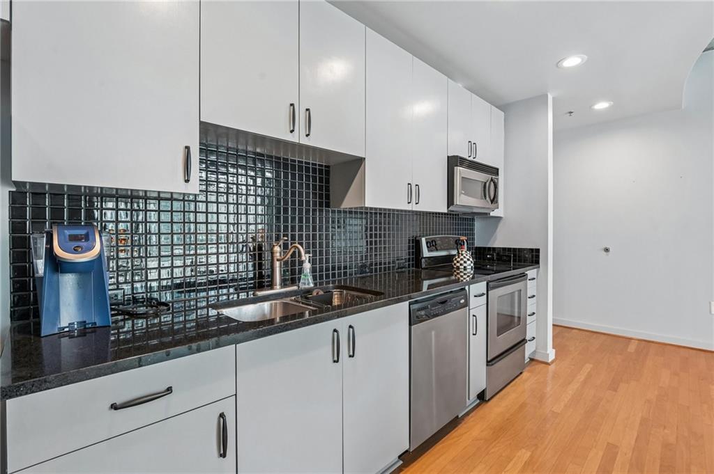 250 Pharr Road Northeast, Unit 701 Atlanta, GA 30305 - Photo 6 of 21 a kitchen with stainless steel appliances a sink a stove and cabinets