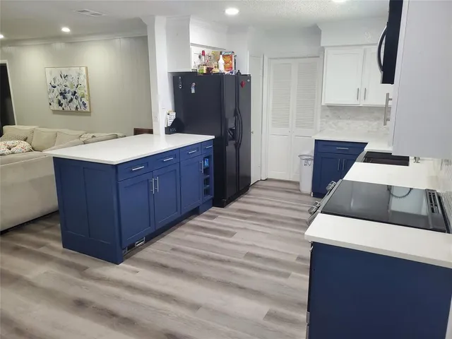 a kitchen with stainless steel appliances a sink a refrigerator and cabinets