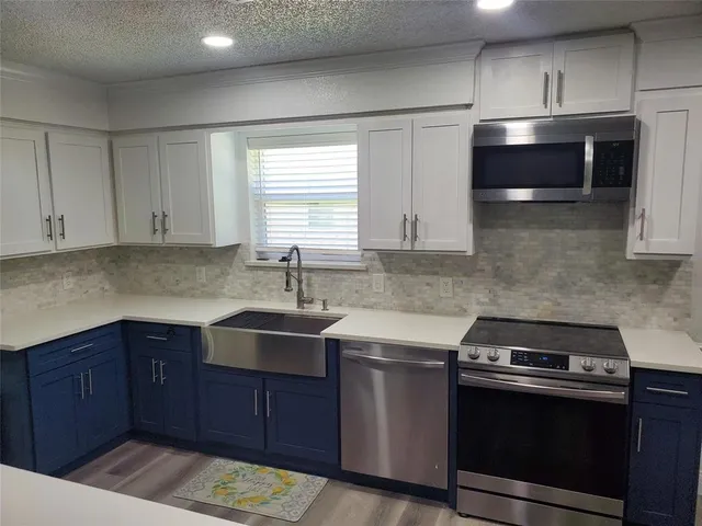 a kitchen with stainless steel appliances a sink stove and cabinets
