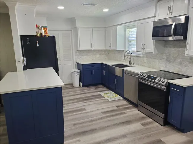 a kitchen with stainless steel appliances granite countertop a sink stove and microwave