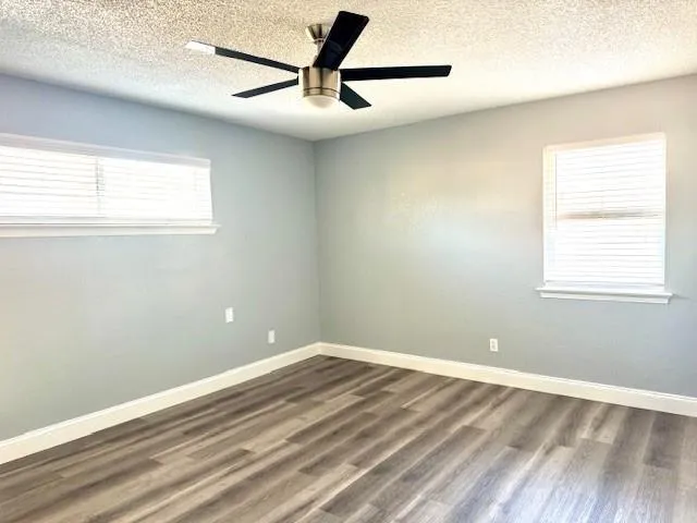 a view of a big room with wooden floor and a window