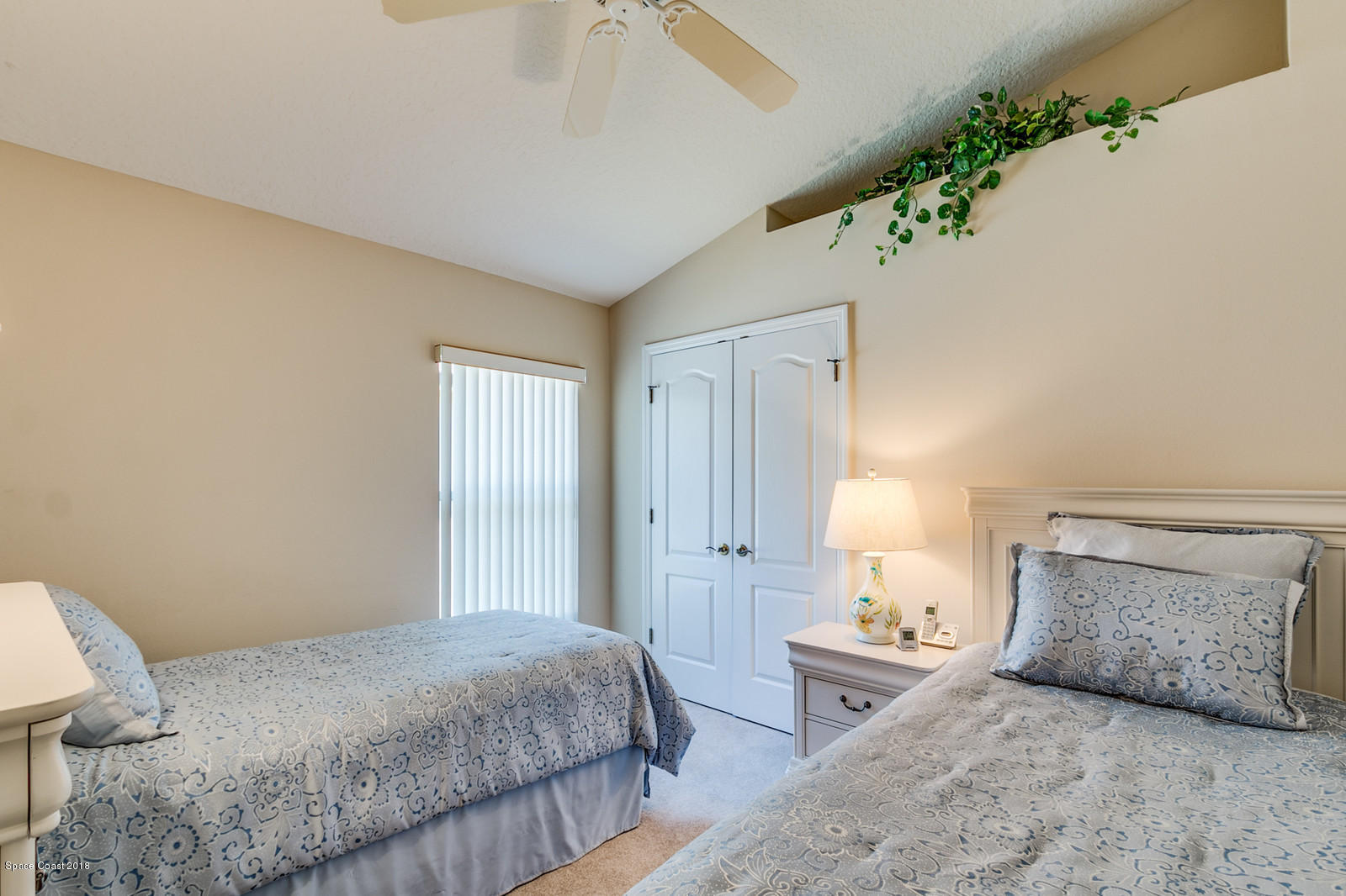 1253 Foxridge Place Melbourne, FL 32940 - Photo 17 of 22 a bedroom with a large bed and a chandelier