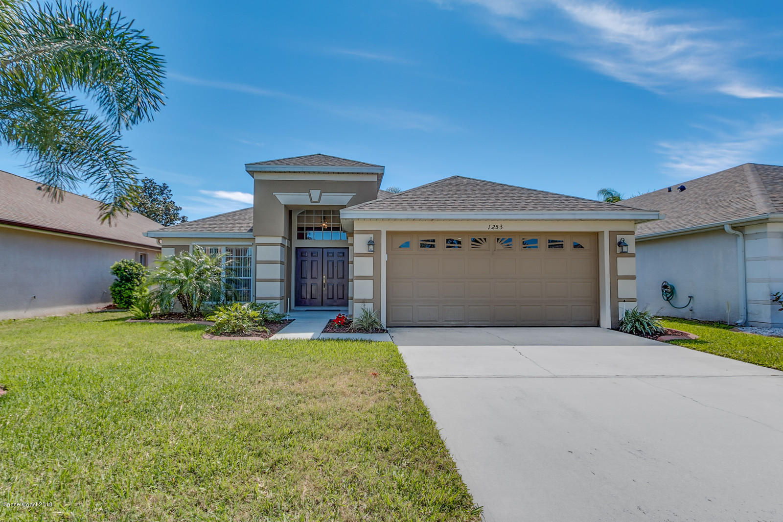 1253 Foxridge Place Melbourne, FL 32940 - Photo 3 of 22 a front view of a house with a yard and garage
