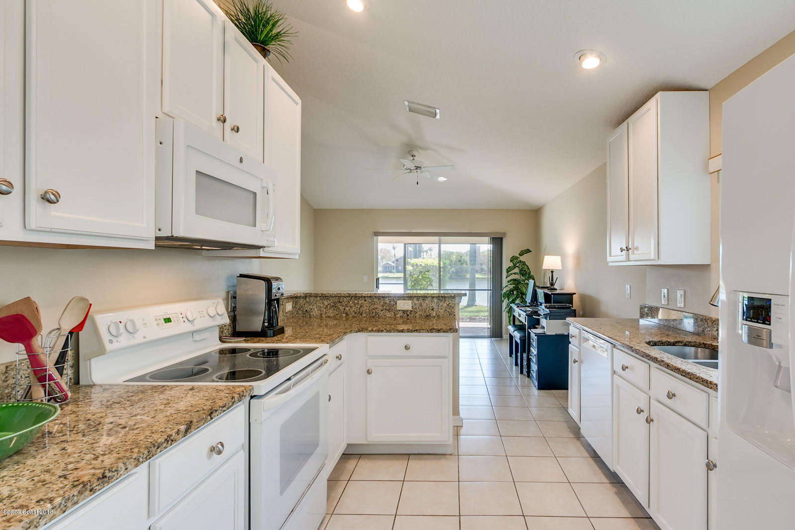 1253 Foxridge Place Melbourne, FL 32940 - Photo 5 of 22 a kitchen with granite countertop a sink a stove and cabinets