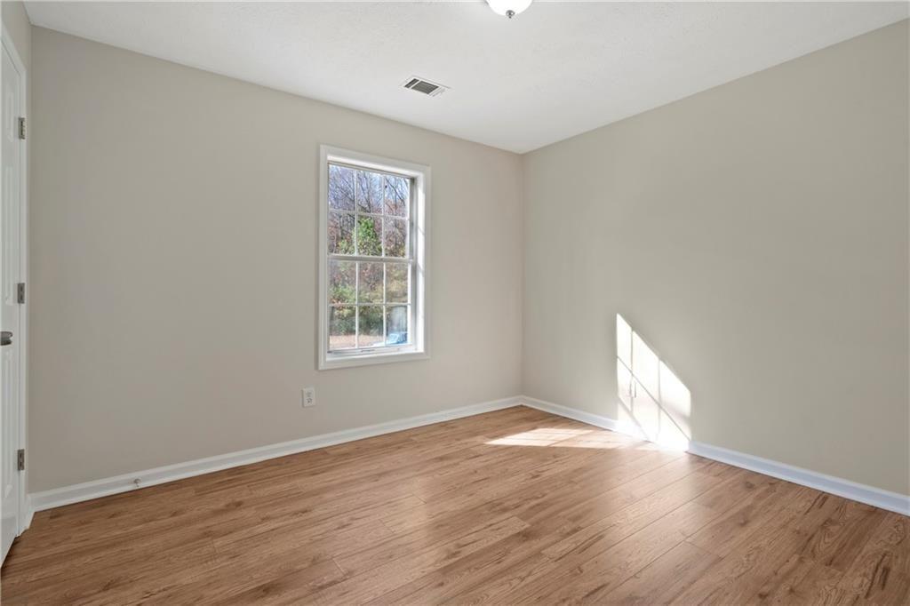 3323 Old Oaks Road Buford, GA 30519 - Photo 11 of 24 a view of an empty room with wooden floor and a window